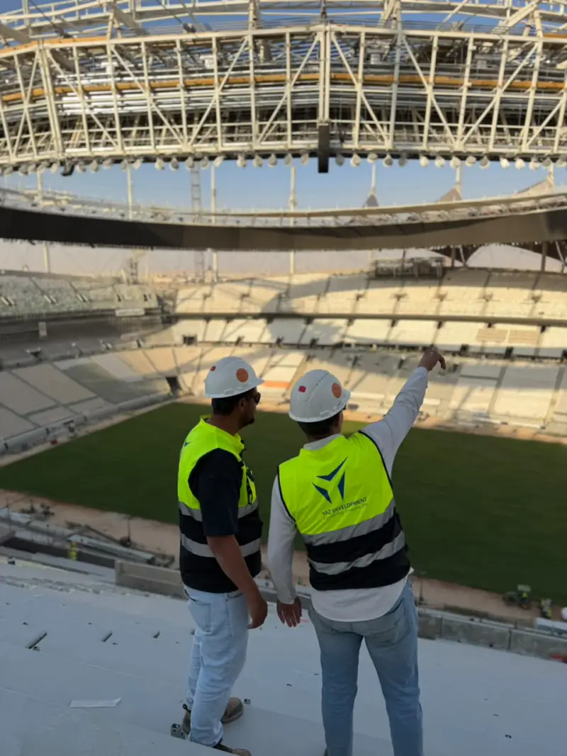 Two YAZ survey engineers reviewing the roof structure inside King Fahd Stadium